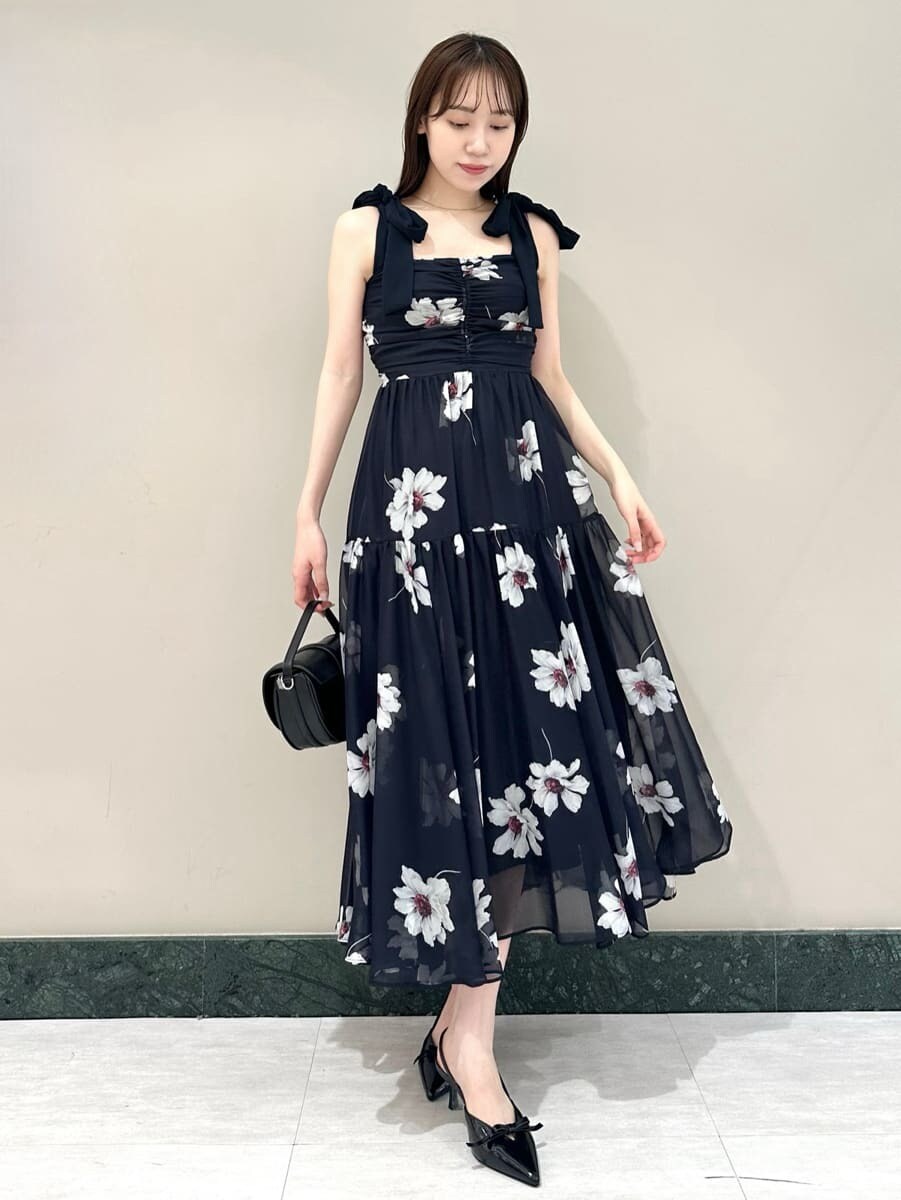 ブルー系のワンピース、ホワイト系のカーディガン/ボレロ、ブラック系のハンドバッグを着用したレディースの夏コーディネートの2枚目の写真