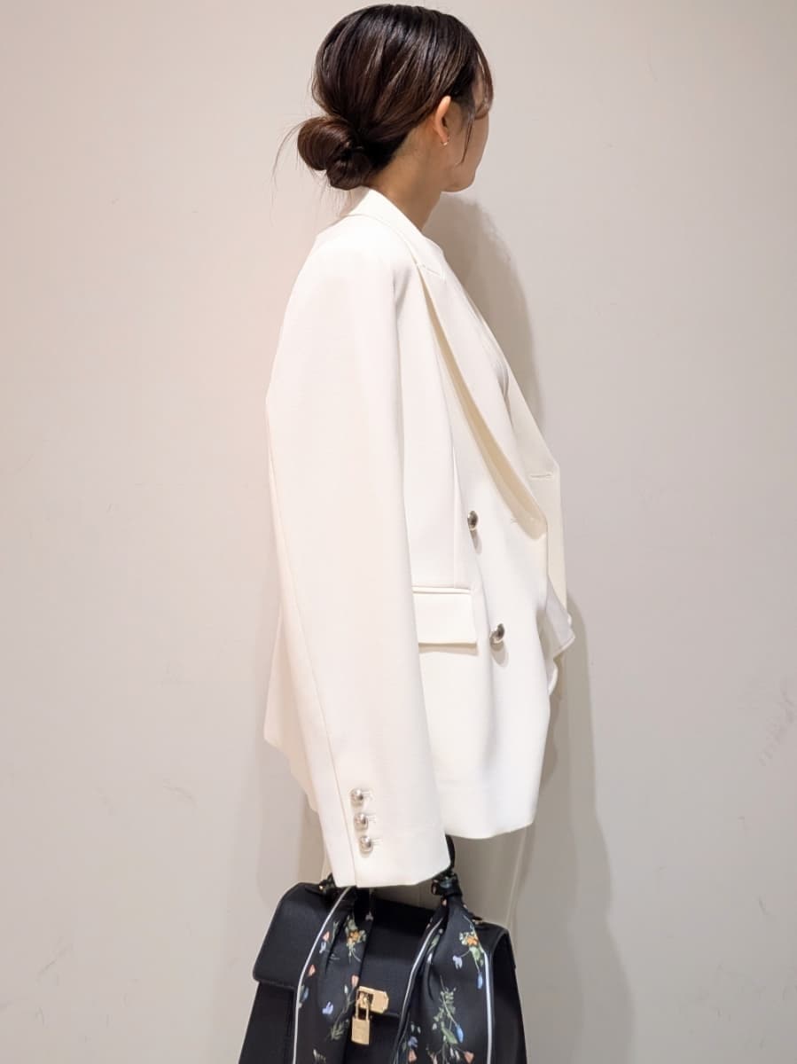 ホワイト系のテーラードジャケット、ホワイト系のワンピース、ブラック系のパンプスを着用したレディースの春コーディネートの4枚目の写真
