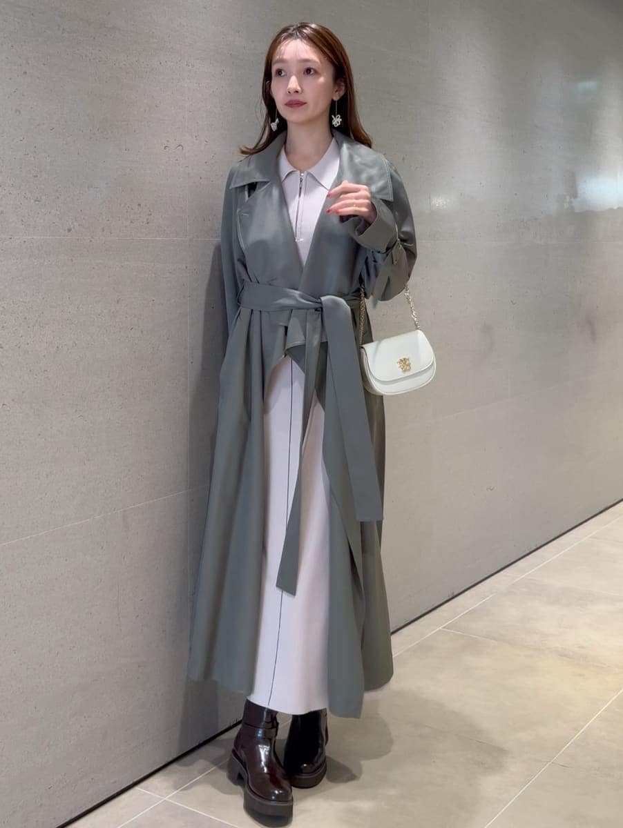 ホワイト系のワンピース、グリーン系のトレンチコート、ホワイト系のショルダーバッグを着用したレディースの冬コーディネートの5枚目の写真