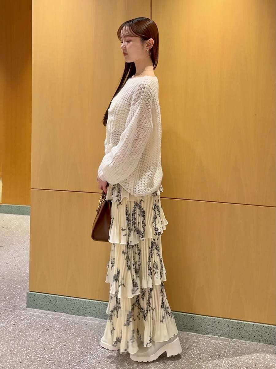 ホワイト系のニット/セーター、ブラウン系のハンドバッグ、イエロー系のスカートを着用したレディースの冬コーディネートの2枚目の写真