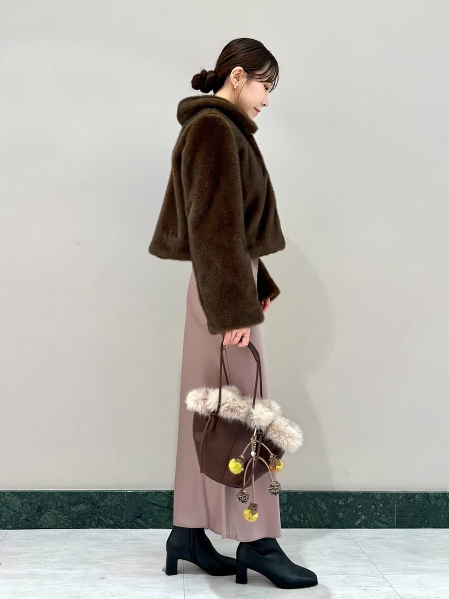 ブラウン系のステンカラーコート、ブラウン系のワンピース、ブラウン系のハンドバッグを着用したレディースの秋コーディネートの3枚目の写真