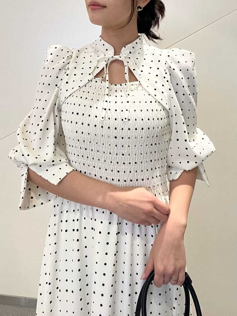 ブラック系のパンプス、ブラック系のボストンバッグ、ホワイト系のワンピースを着用したレディースの春コーディネートの4枚目の写真