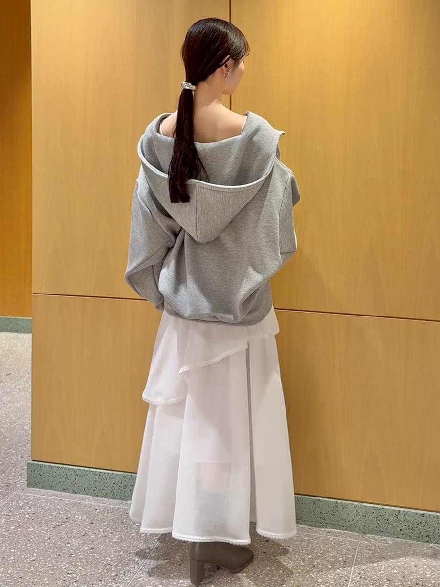 ホワイト系のショルダーバッグ、ホワイト系のスカート、グレー系のパーカーを着用したレディースの冬コーディネートの3枚目の写真