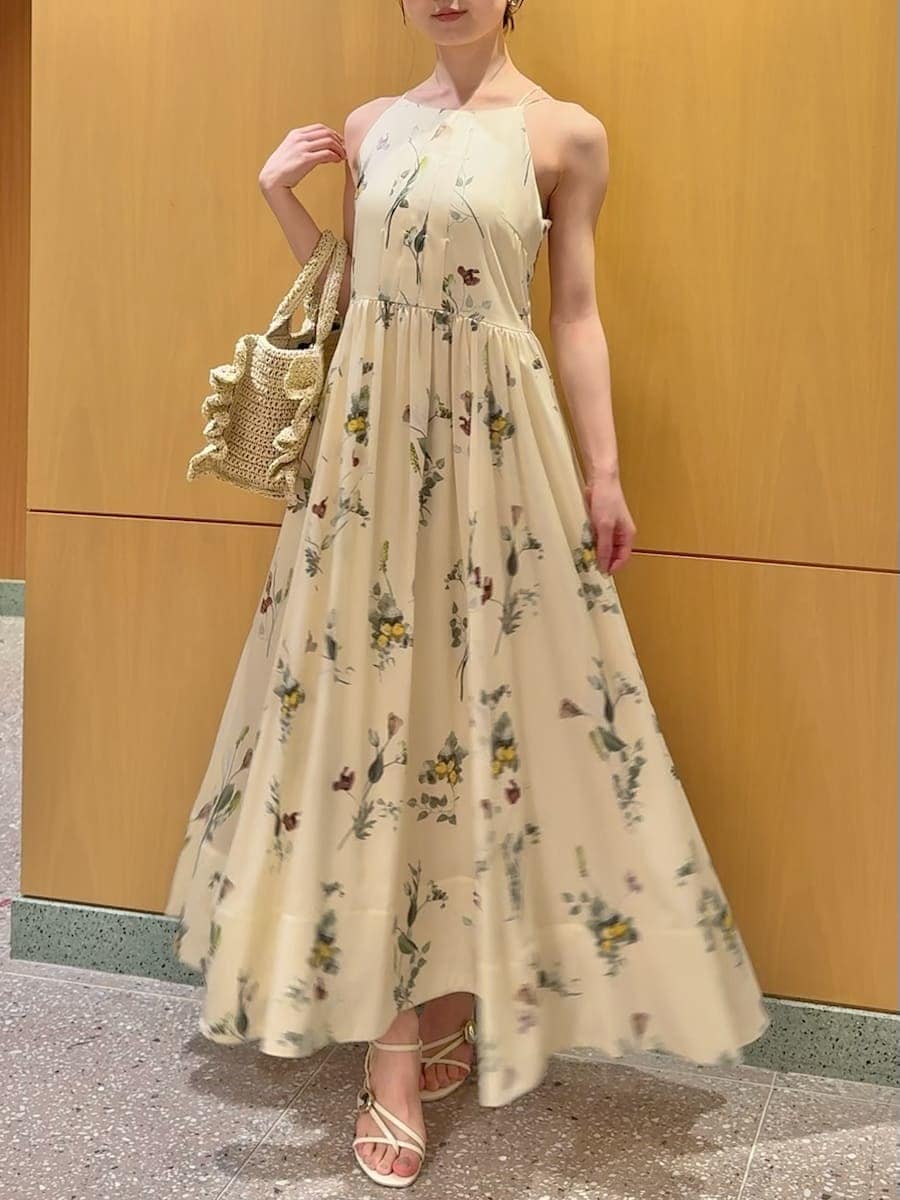 イエロー系のワンピース、ホワイト系のカーディガン/ボレロ、ベージュ系のショルダーバッグを着用したレディースの春コーディネートの3枚目の写真