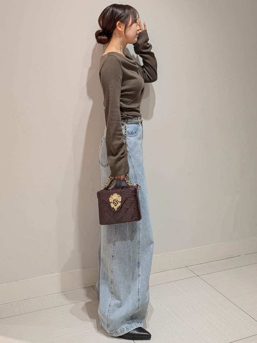 ブルー系のデニムパンツ、ブラウン系のニット/セーター、ブラウン系のパンプスを着用したレディースの秋コーディネートの2枚目の写真