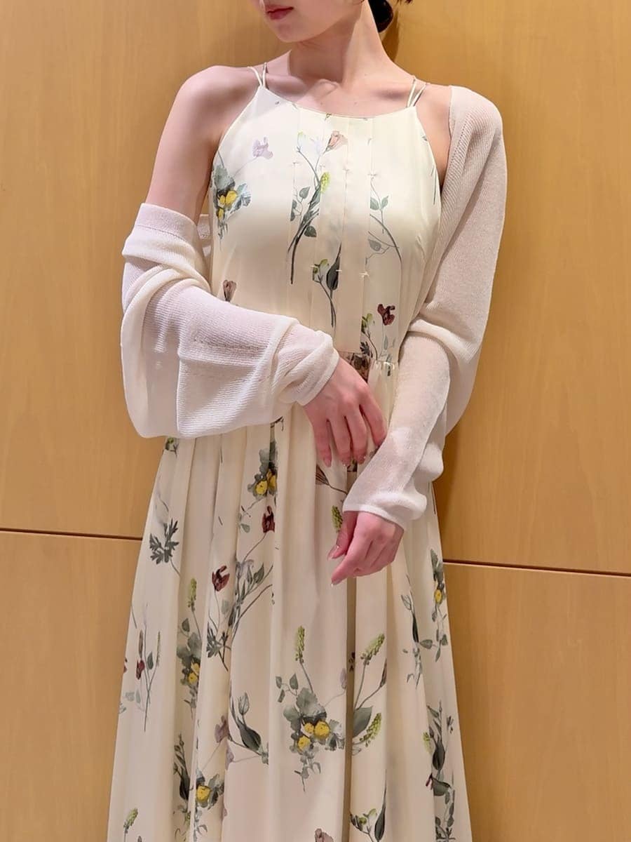 イエロー系のワンピース、ホワイト系のカーディガン/ボレロ、ベージュ系のショルダーバッグを着用したレディースの春コーディネートの5枚目の写真