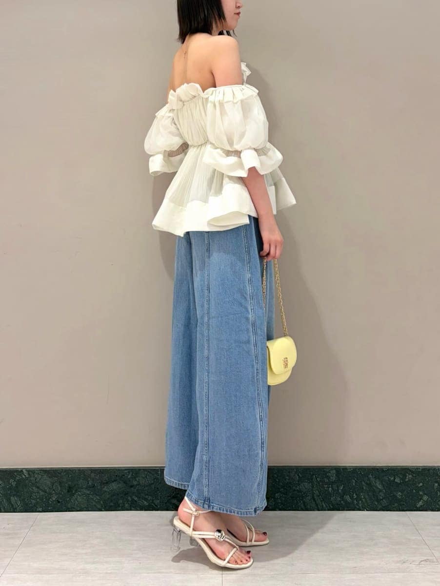 ブルー系のデニムパンツ、ホワイト系のその他トップス、イエロー系のショルダーバッグを着用したレディースの春コーディネートの4枚目の写真