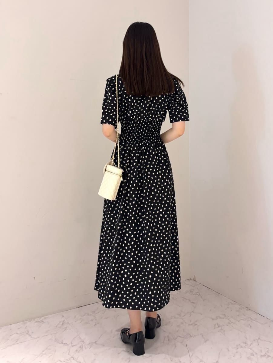 ブラック系のワンピース、ホワイト系のショルダーバッグ、ブラック系のパンプスを着用したレディースの夏コーディネートの3枚目の写真