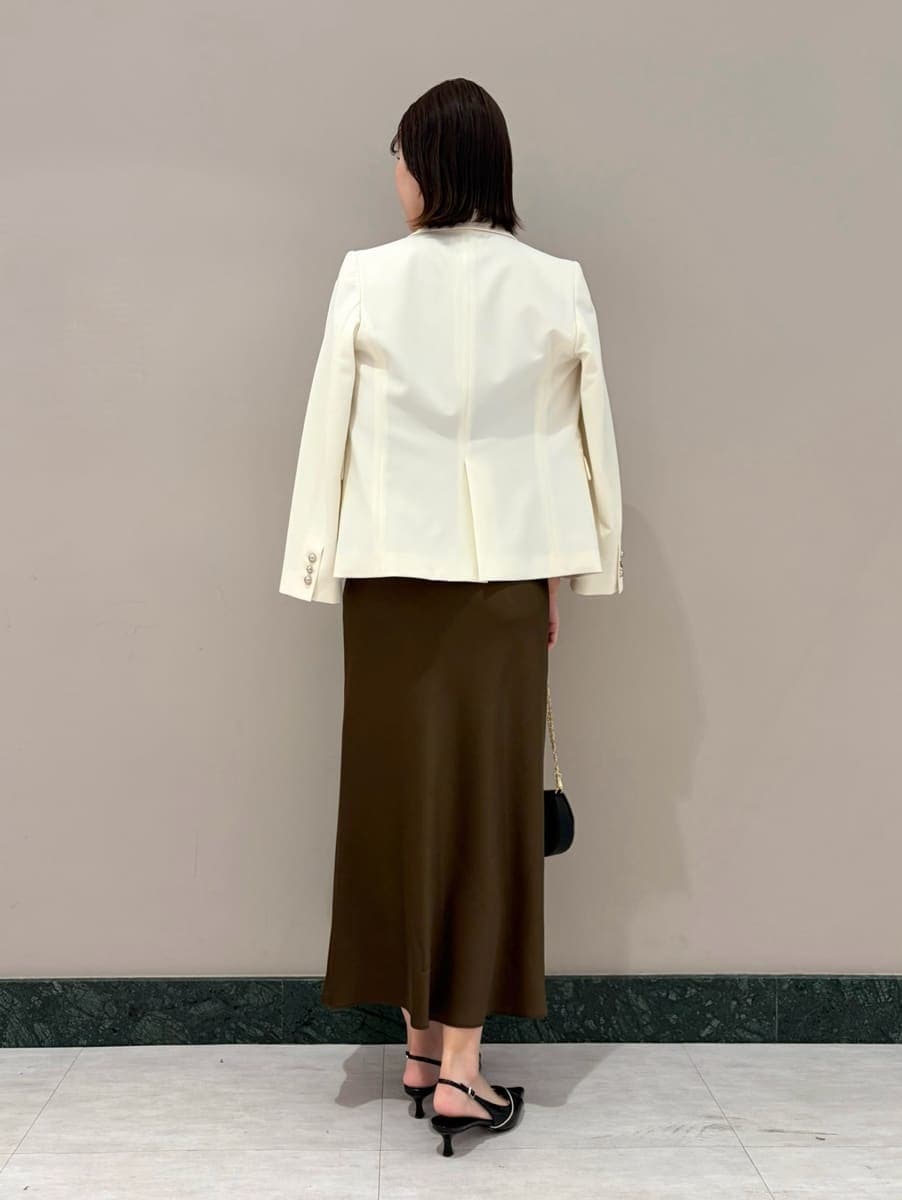 ホワイト系のテーラードジャケット、ブラック系のパンプス、ブラック系のショルダーバッグを着用したレディースの春コーディネートの5枚目の写真