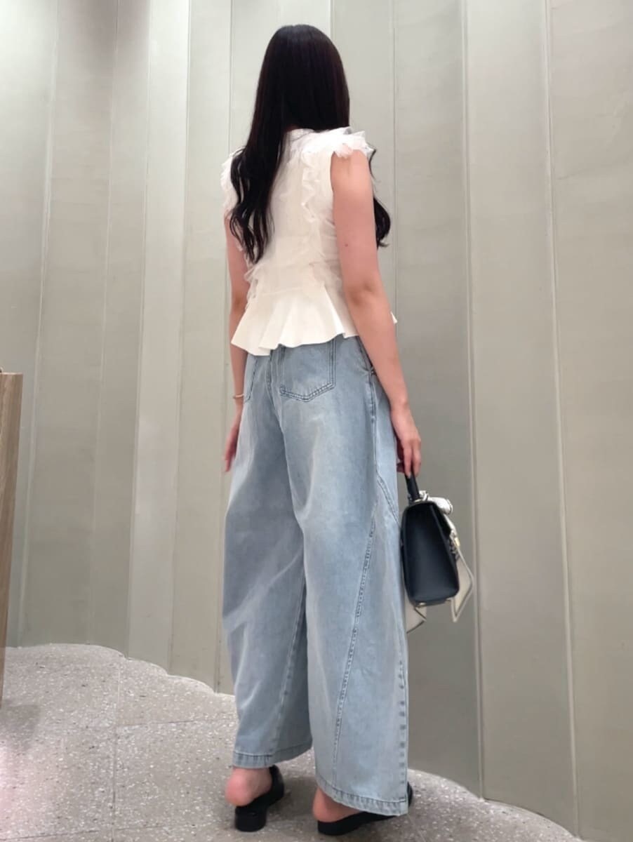 ブラック系のハンドバッグ、ブルー系のデニムパンツ、ホワイト系のニット/セーターを着用したレディースの夏コーディネートの4枚目の写真