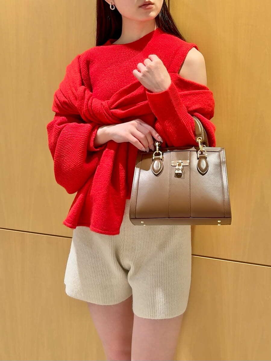 ホワイト系のその他パンツ、レッド系のニット/セーター、ブラウン系のハンドバッグを着用したレディースの冬コーディネートの7枚目の写真