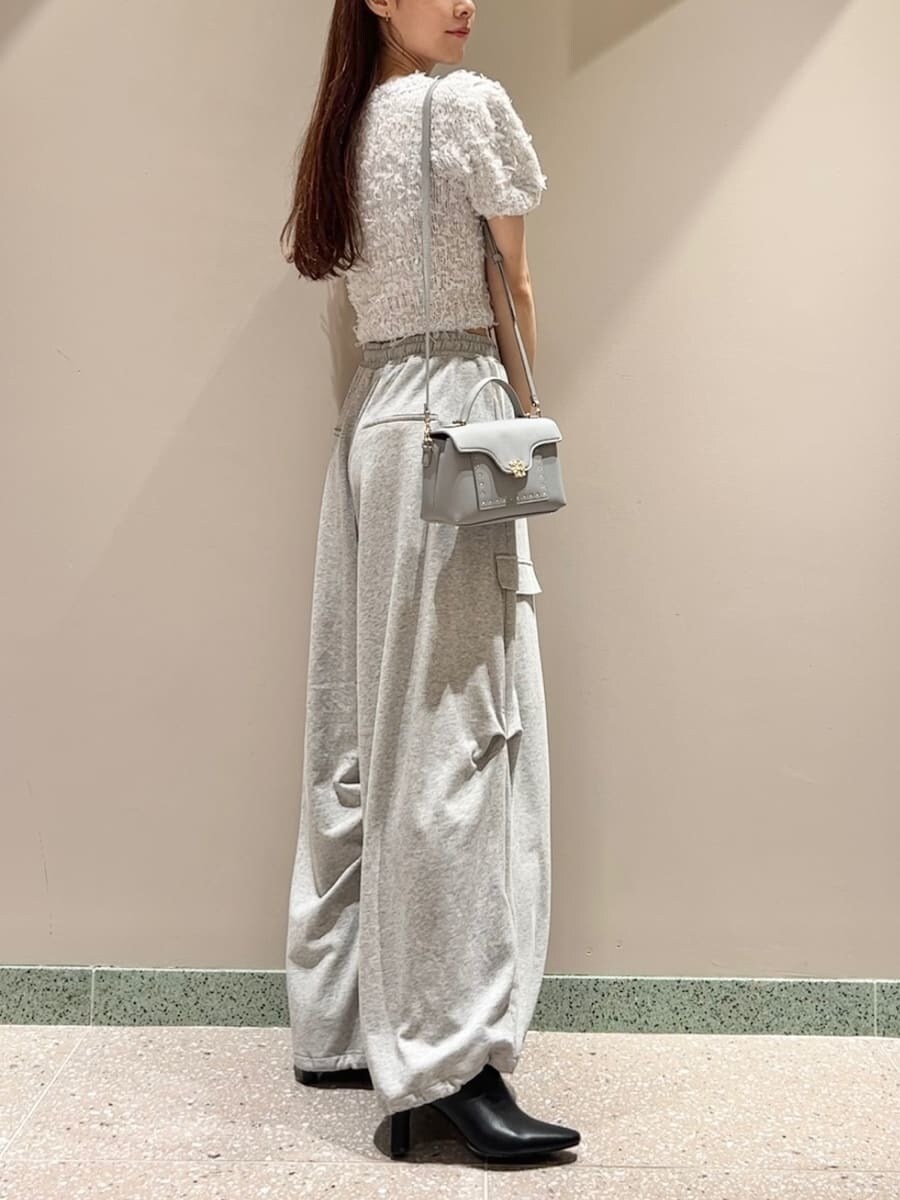 グレー系のニット/セーター、グレー系のその他パンツ、ブルー系のショルダーバッグを着用したレディースの夏コーディネートの3枚目の写真