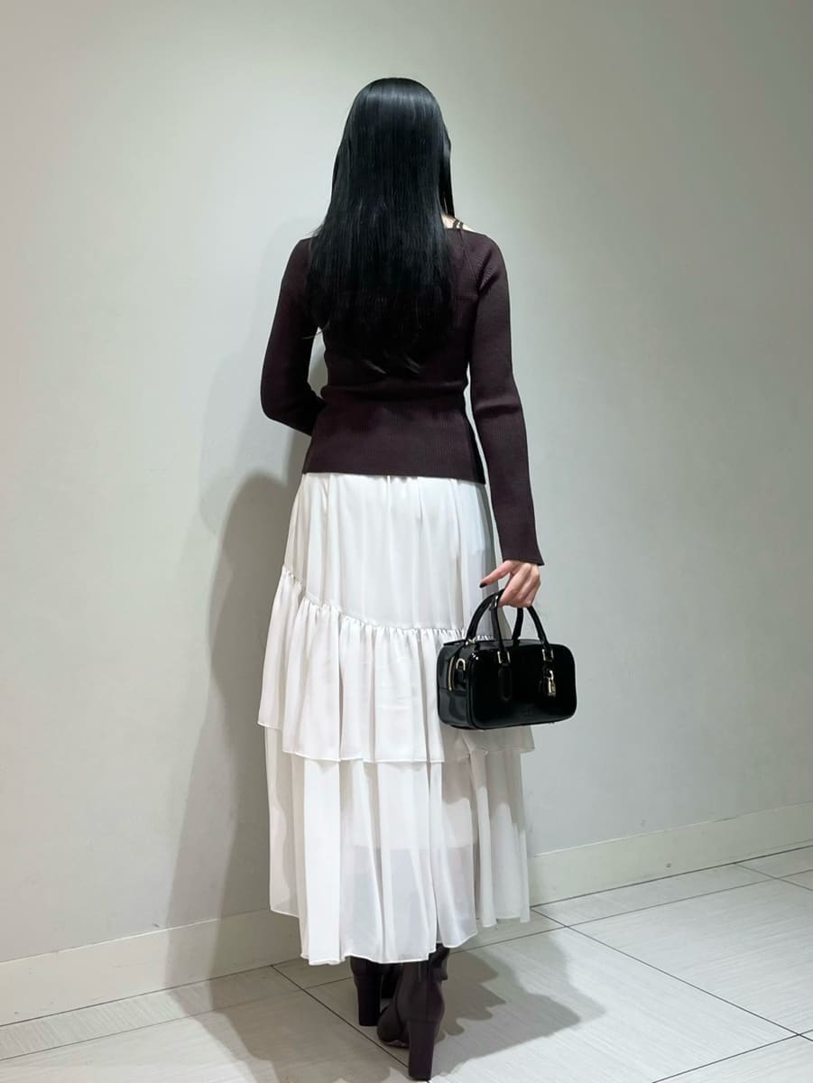 ブラウン系のニット/セーター、ホワイト系のスカート、ブラック系のボストンバッグを着用したレディースの秋コーディネートの3枚目の写真