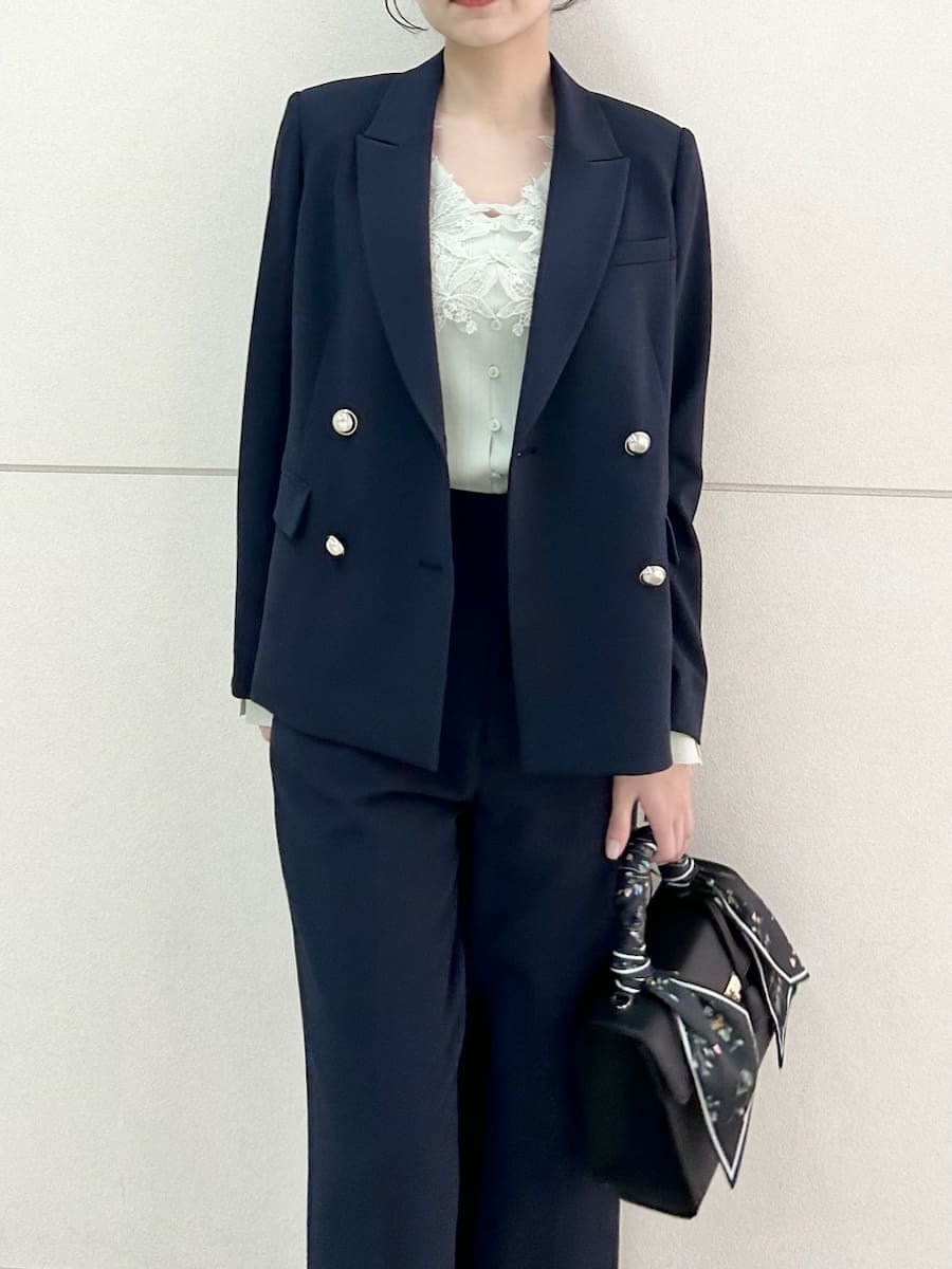 ブルー系のテーラードジャケット、ブルー系のスラックス、ブラック系のハンドバッグを着用したレディースの冬コーディネートの6枚目の写真