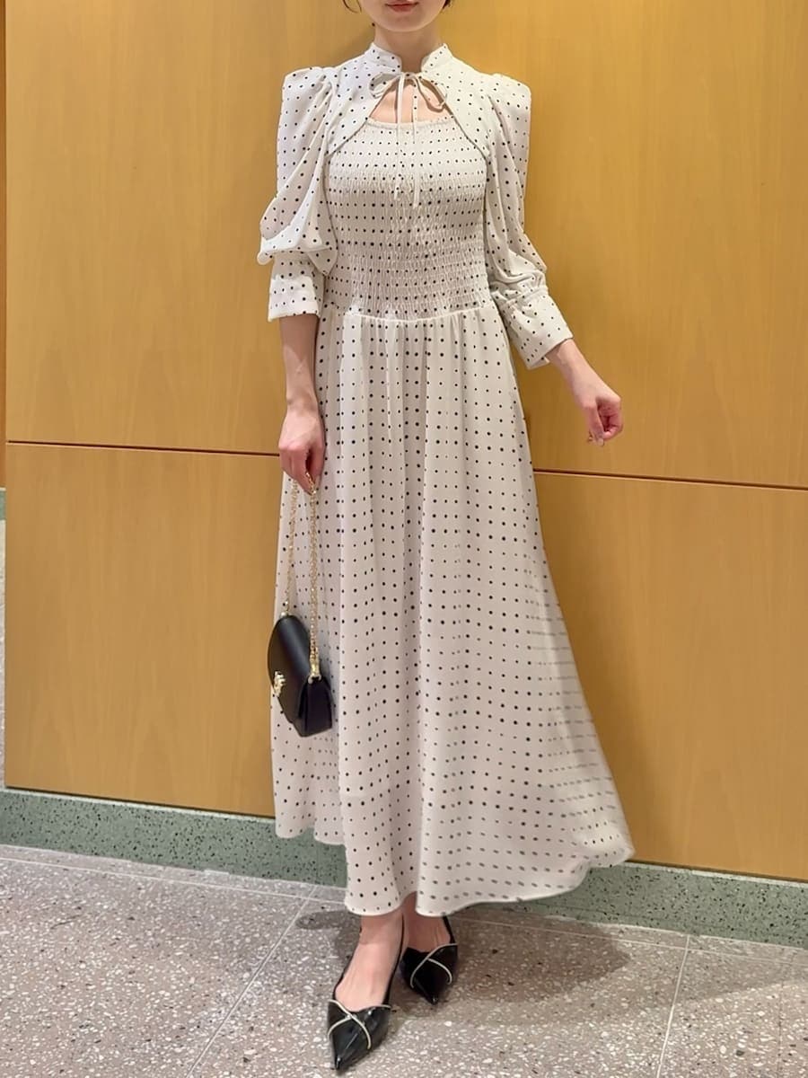 ブラック系のパンプス、ブラック系のショルダーバッグ、ホワイト系のワンピースを着用したレディースの春コーディネートの4枚目の写真