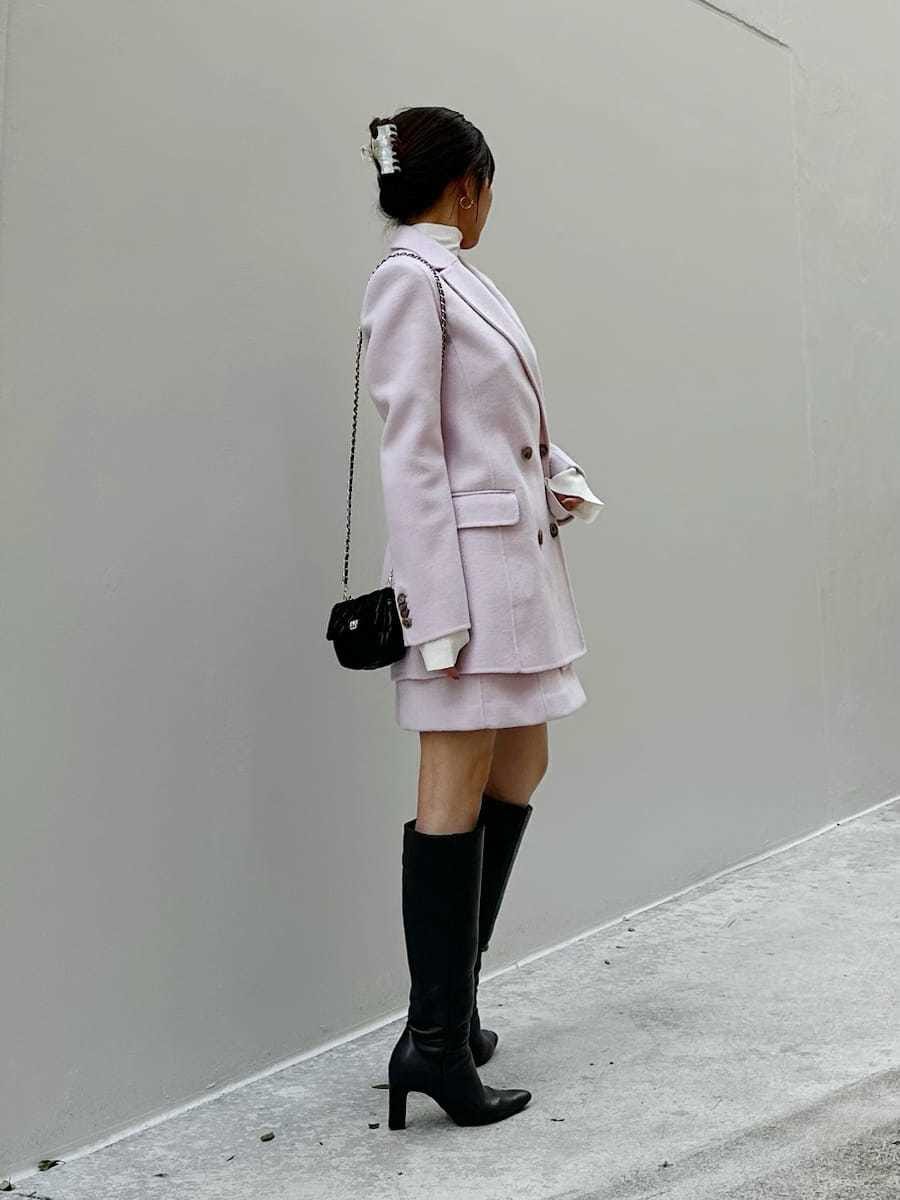 ピンク系のワンピース、ピンク系のテーラードジャケット、ブラック系のニット/セーターを着用したレディースの秋コーディネートの3枚目の写真