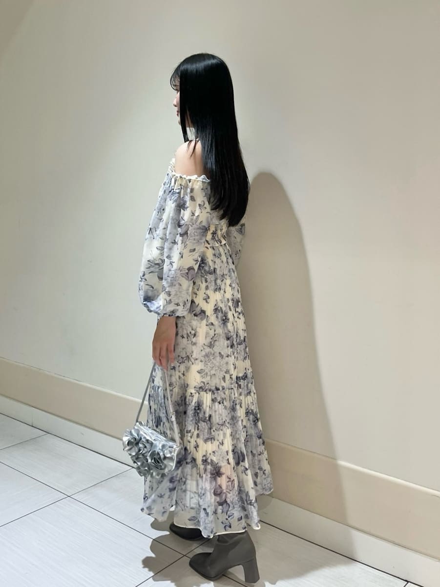 イエロー系のワンピース、シルバー系のハンドバッグを着用したレディースの冬コーディネートの2枚目の写真