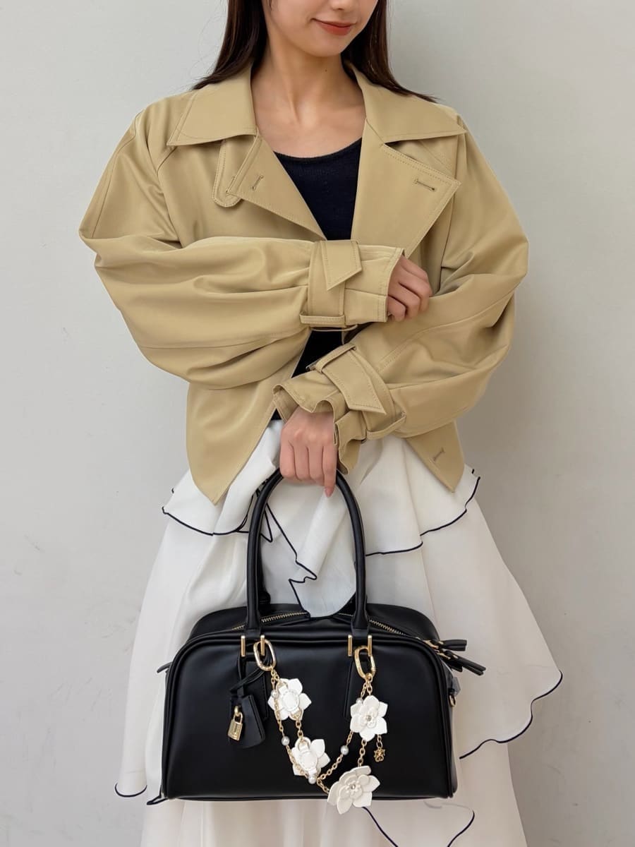 ベージュ系のトレンチコート、ブルー系のワンピース、ブラック系のパンプスを着用したレディースの冬コーディネートの4枚目の写真