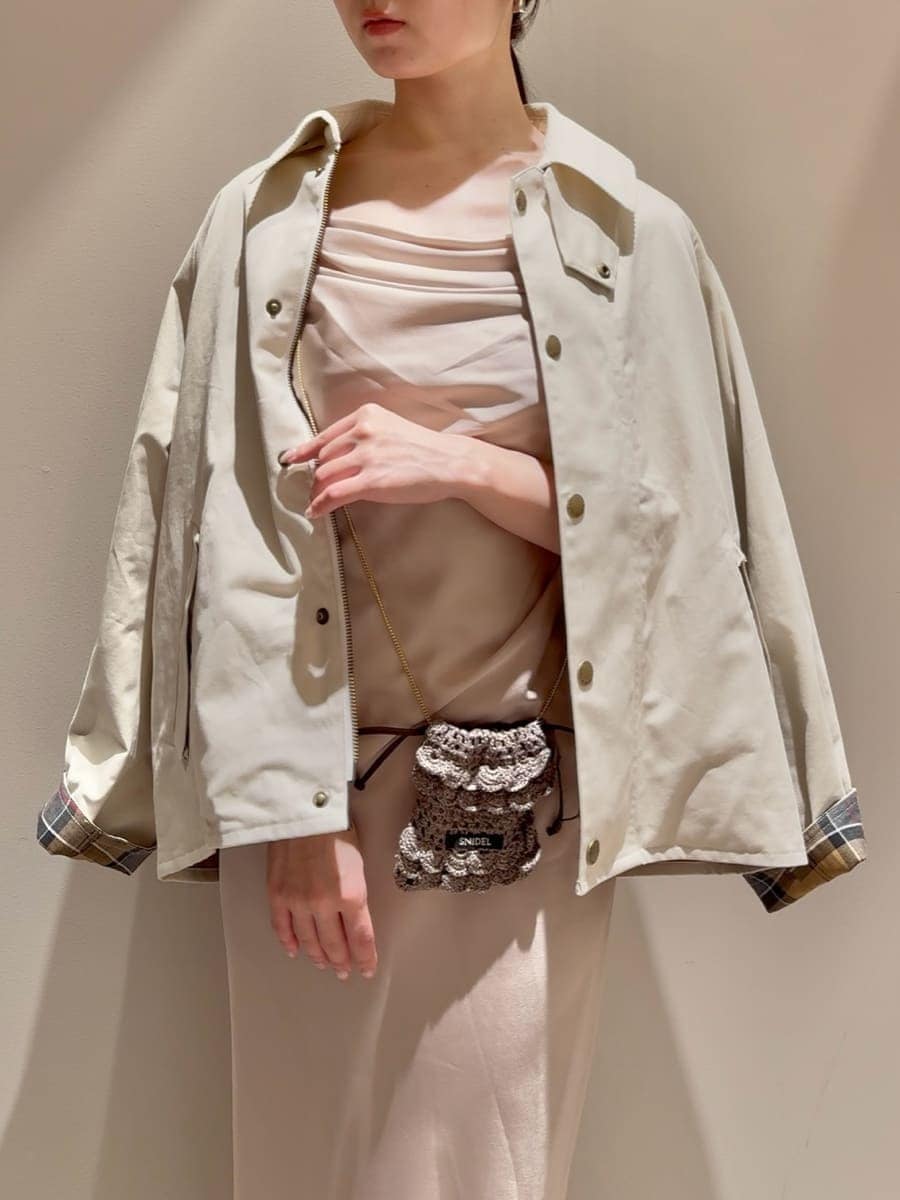 ホワイト系のブルゾン、ブラウン系のチャームを着用したレディースの秋コーディネートの6枚目の写真