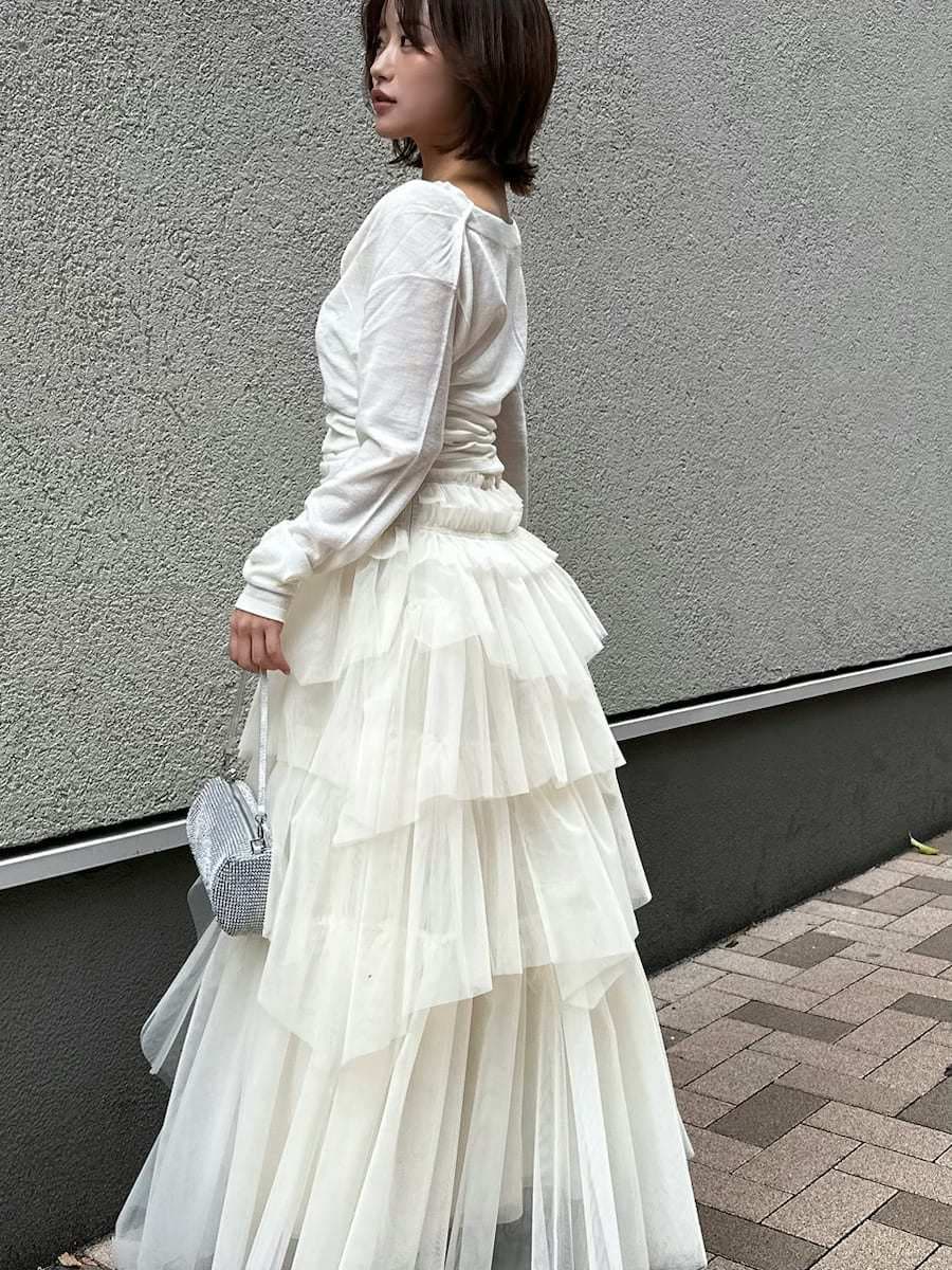 ブラック系のブーツ、ホワイト系のニット/セーター、その他のピアス（両耳用）を着用したレディースの冬コーディネートの3枚目の写真