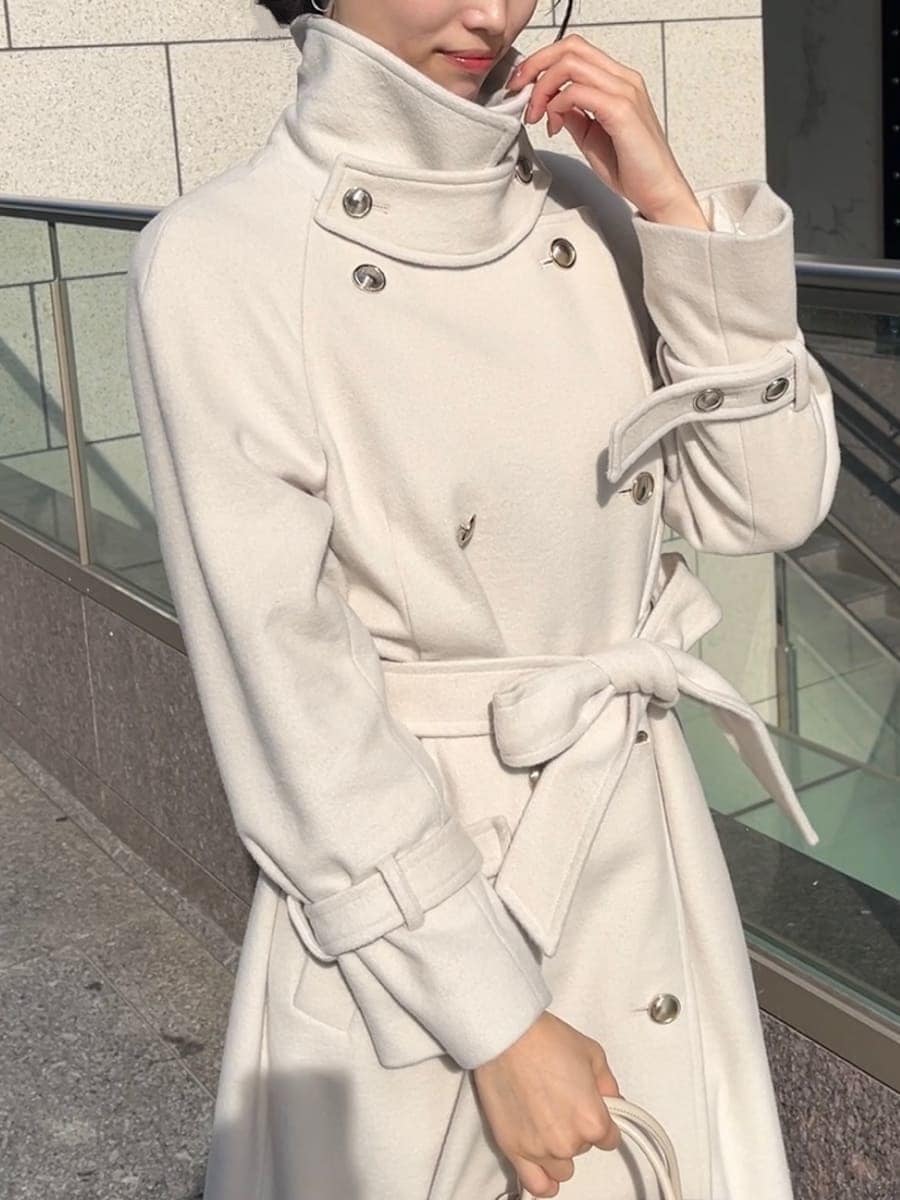 ホワイト系のチェスターコート、ホワイト系のワンピース、ホワイト系のボストンバッグを着用したレディースの秋コーディネートの5枚目の写真