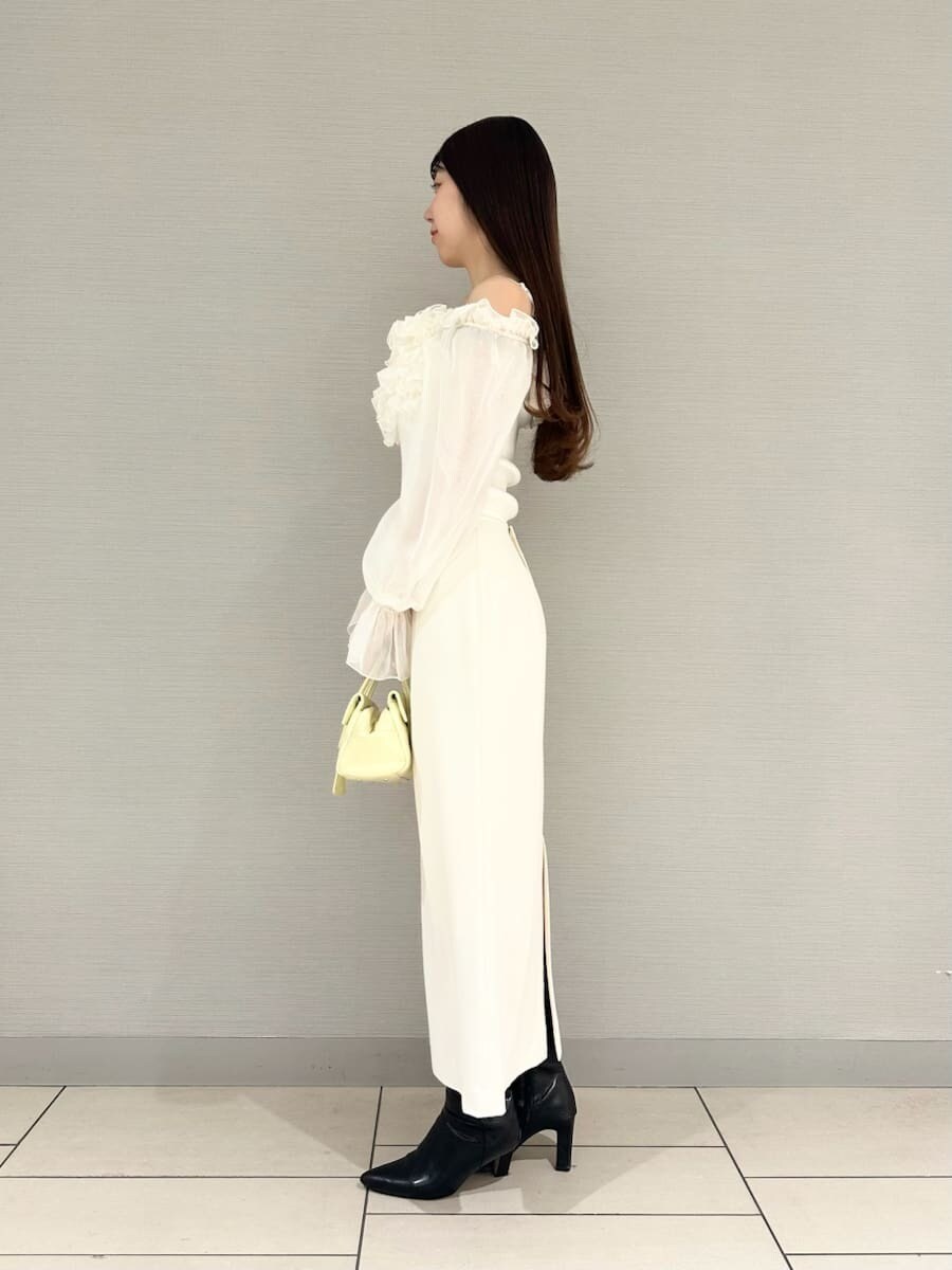 ホワイト系のスカート、ホワイト系のニット/セーター、イエロー系のボストンバッグを着用したレディースの冬コーディネートの2枚目の写真