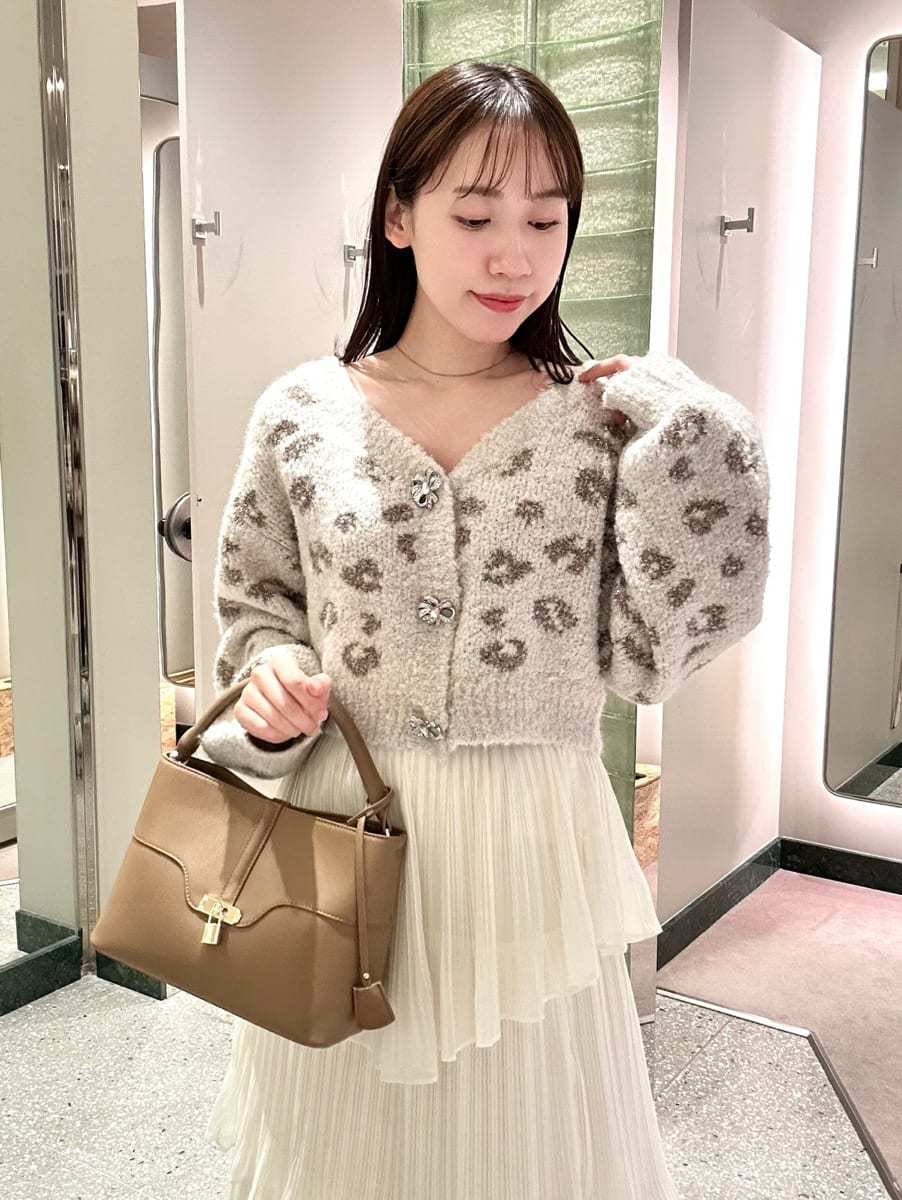 グレー系のダウンジャケット/コート、ホワイト系のスカート、その他のカーディガン/ボレロを着用したレディースの秋コーディネートの4枚目の写真