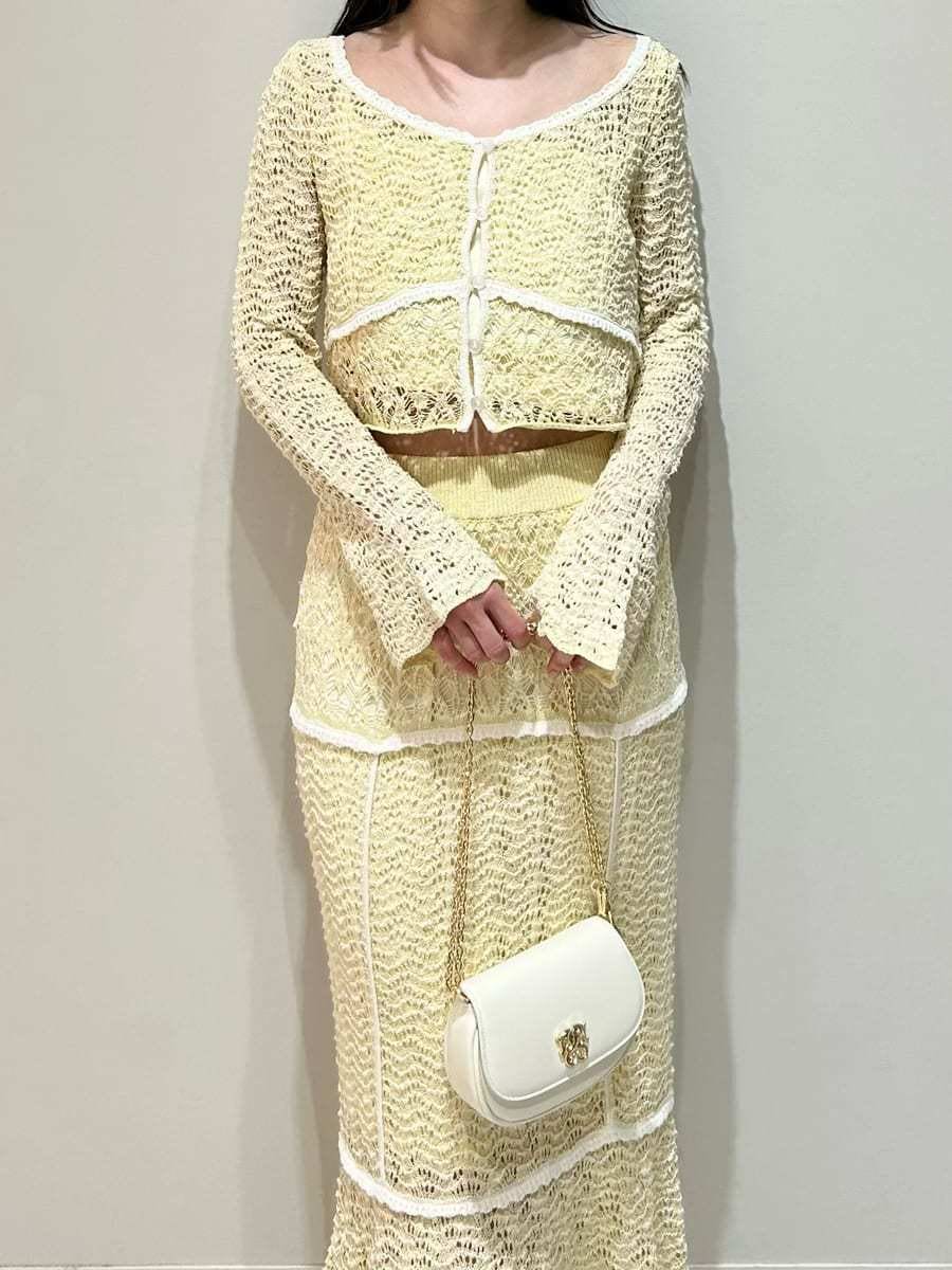 イエロー系のスカート、イエロー系のニット/セーター、ホワイト系のショルダーバッグを着用したレディースの春コーディネートの3枚目の写真