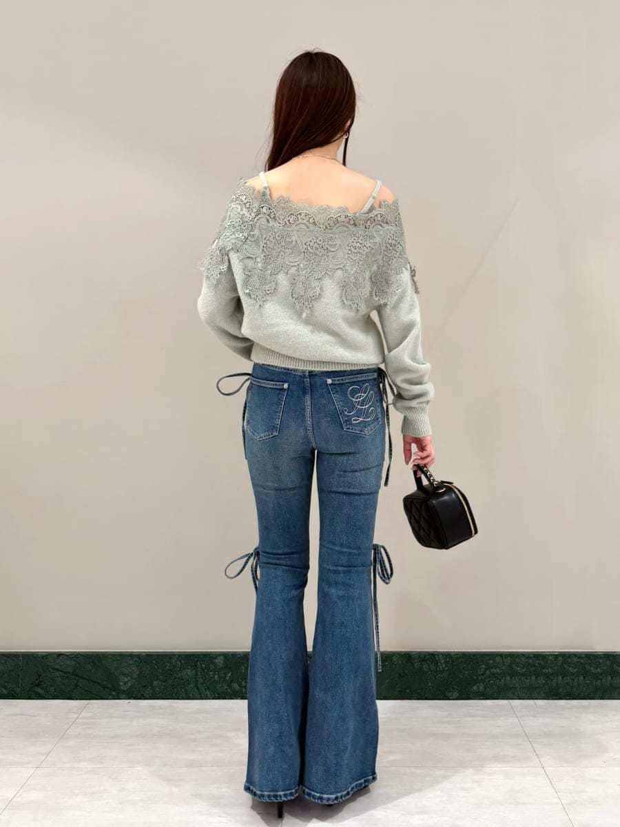 ブルー系のデニムパンツ、グリーン系のニット/セーター、ブラック系のサンダルを着用したレディースの秋コーディネートの3枚目の写真