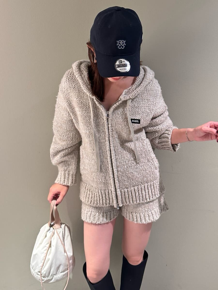 ホワイト系のその他パンツ、ホワイト系のニット/セーター、ベージュ系のハンドバッグを着用したレディースの夏コーディネートの3枚目の写真