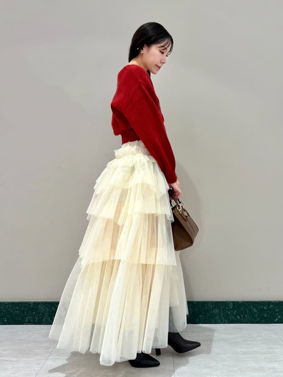 ブラウン系のブーツ、レッド系のカーディガン/ボレロ、ブラウン系のハンドバッグを着用したレディースの冬コーディネートの2枚目の写真