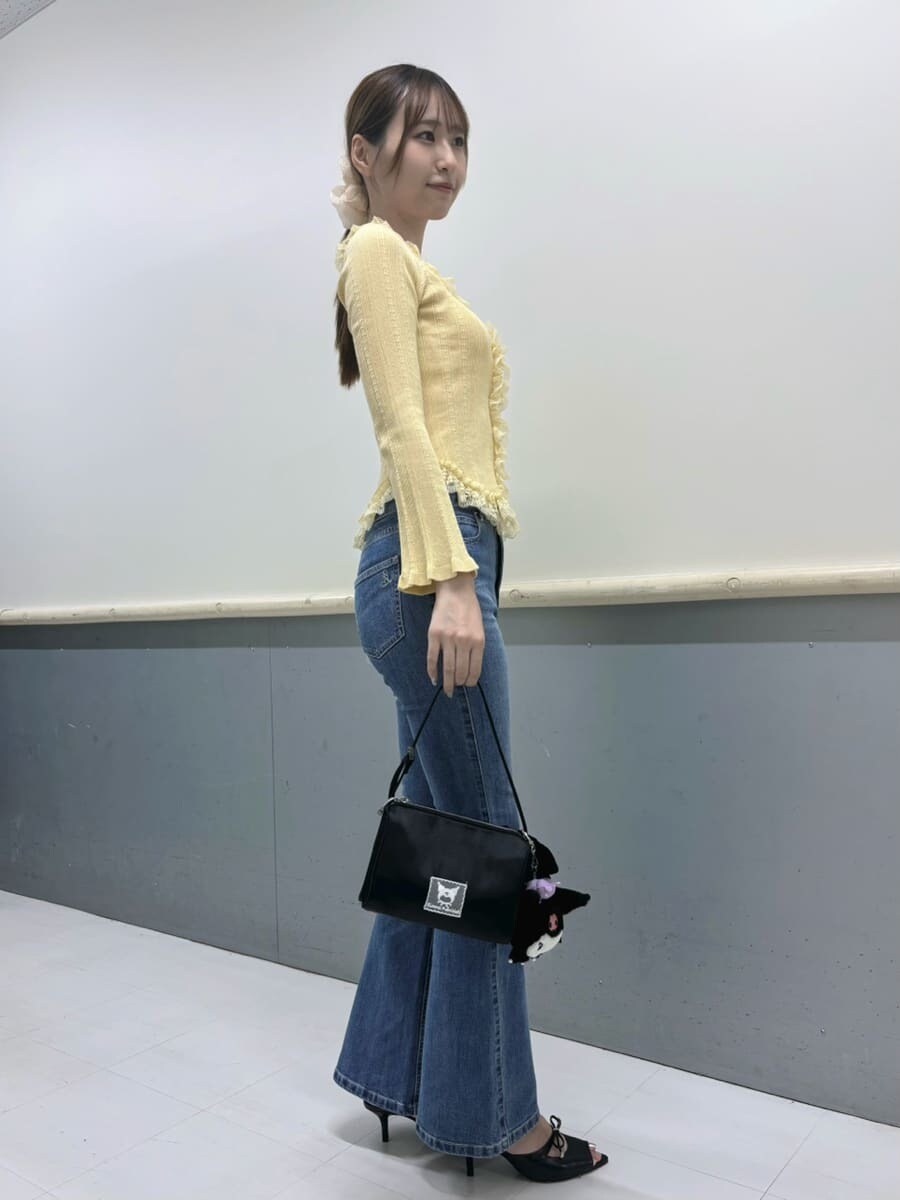 イエロー系のニット/セーター、ブラック系のサンダル、ブルー系のデニムパンツを着用したレディースの夏コーディネートの2枚目の写真