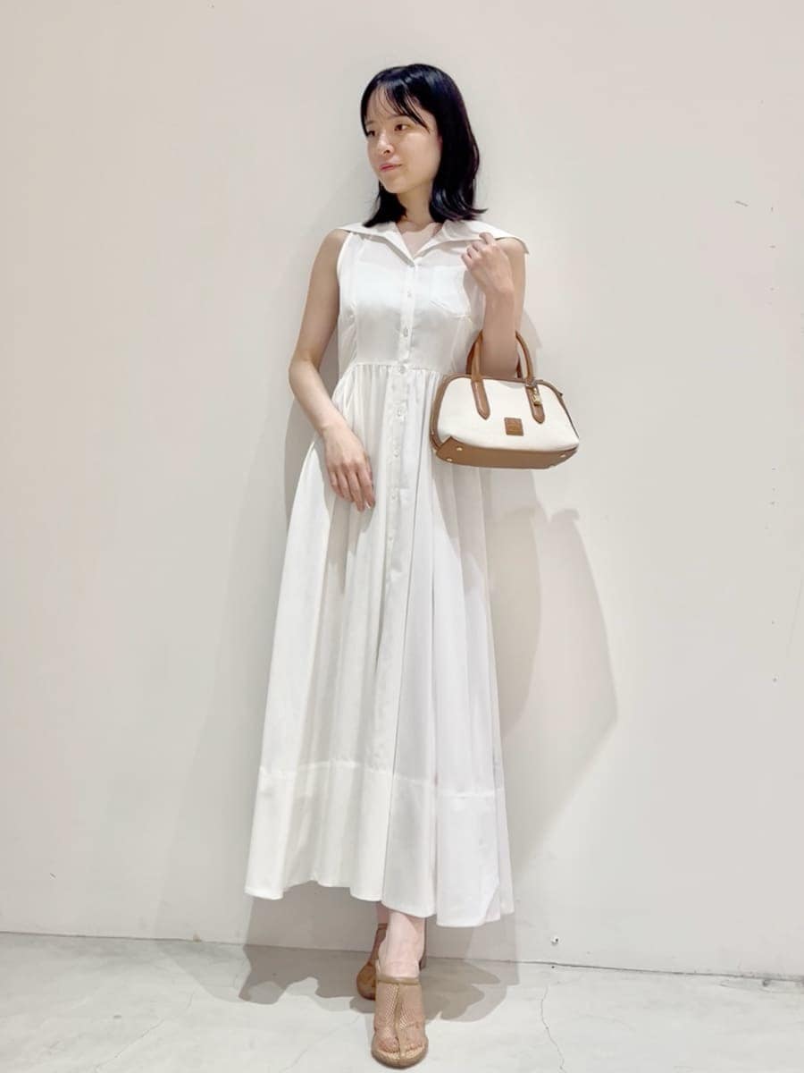 ベージュ系のパンプス、ホワイト系のワンピース、イエロー系のボストンバッグを着用したレディースの夏コーディネートの3枚目の写真