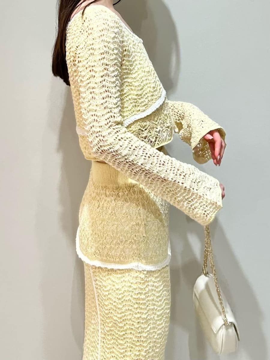 イエロー系のスカート、イエロー系のニット/セーター、ホワイト系のショルダーバッグを着用したレディースの春コーディネートの4枚目の写真