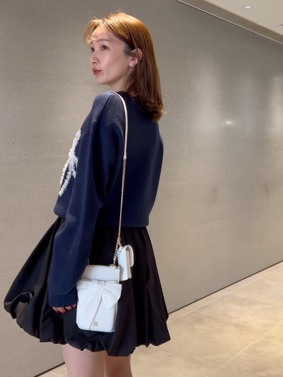 ブラック系のその他パンツ、ブルー系のニット/セーター、ホワイト系のショルダーバッグを着用したレディースの冬コーディネートの4枚目の写真