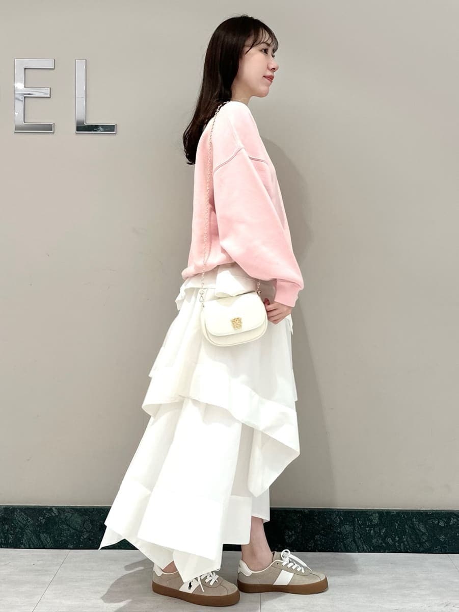 ホワイト系のスカート、ピンク系のスウェット、ホワイト系のショルダーバッグを着用したレディースの春コーディネートの4枚目の写真