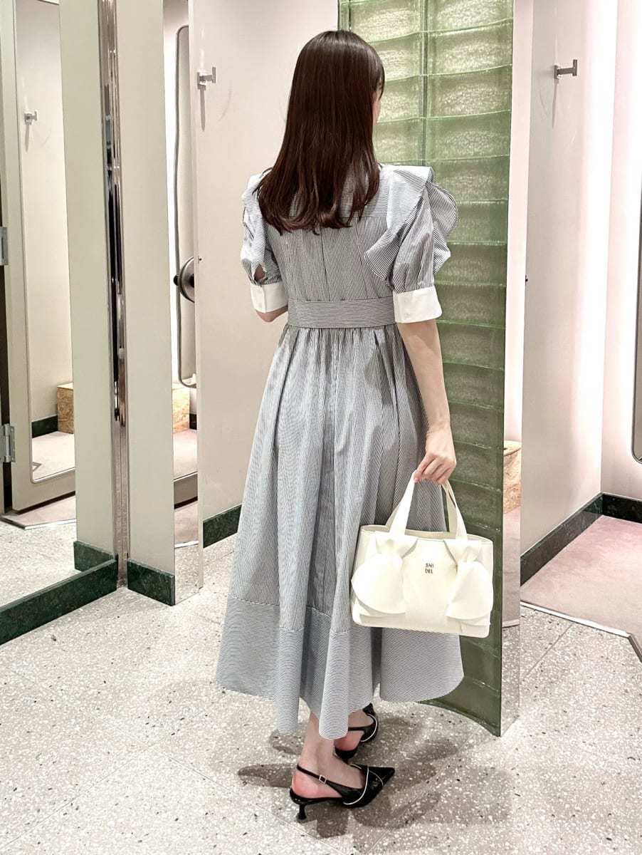 その他のワンピース、ブラック系のパンプス、ホワイト系のハンドバッグを着用したレディースの冬コーディネートの4枚目の写真