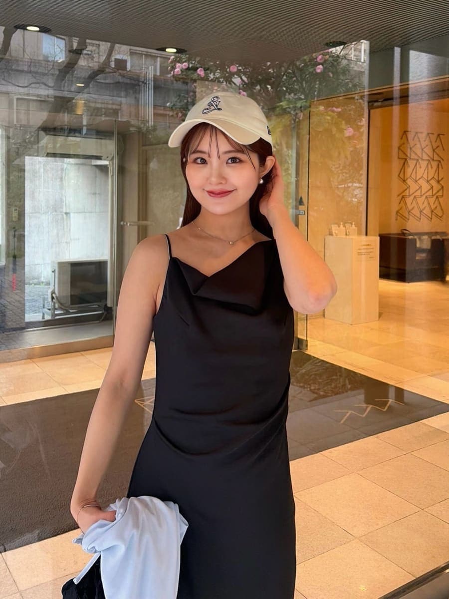 ブラック系のワンピース、ブルー系のカーディガン/ボレロ、ホワイト系のキャップを着用したレディースの春コーディネートの7枚目の写真