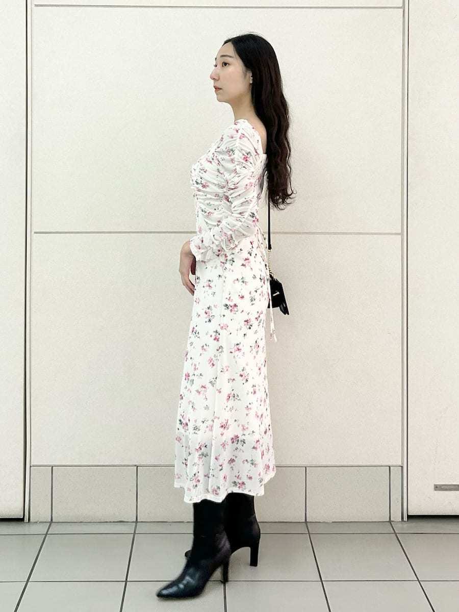 ブラック系のブーツ、ピンク系のワンピース、ブラック系のショルダーバッグを着用したレディースの冬コーディネートの3枚目の写真