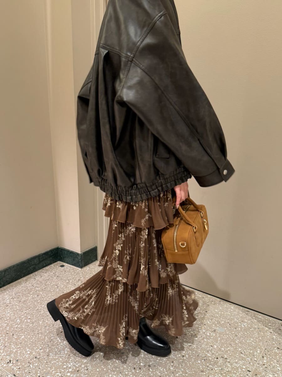 ブラウン系のワンピース、ブラウン系のブルゾン、イエロー系のボストンバッグを着用したレディースの秋コーディネートの6枚目の写真