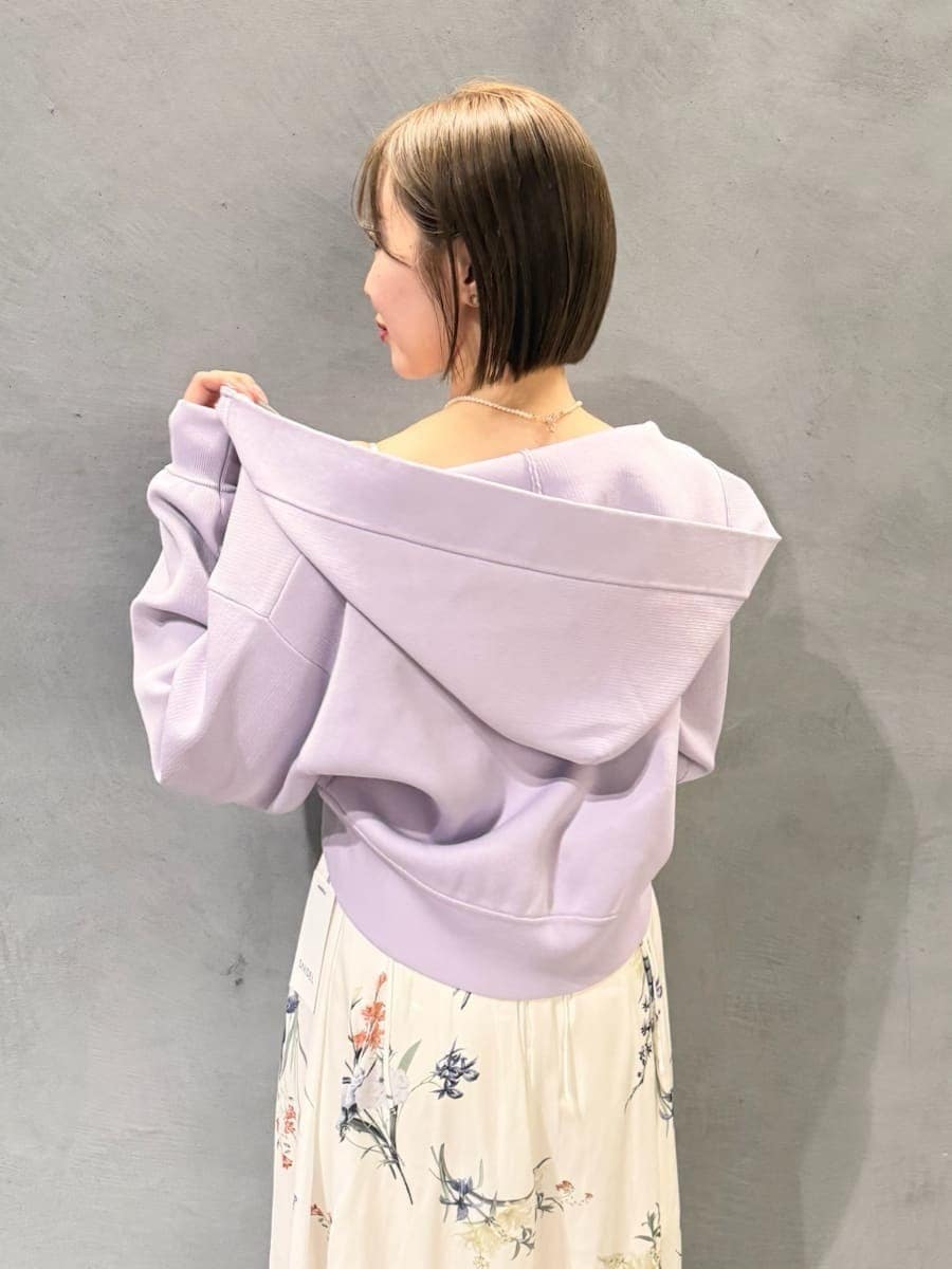 パープル系のパーカー、ホワイト系のワンピース、ブラウン系のパンプスを着用したレディースの冬コーディネートの5枚目の写真