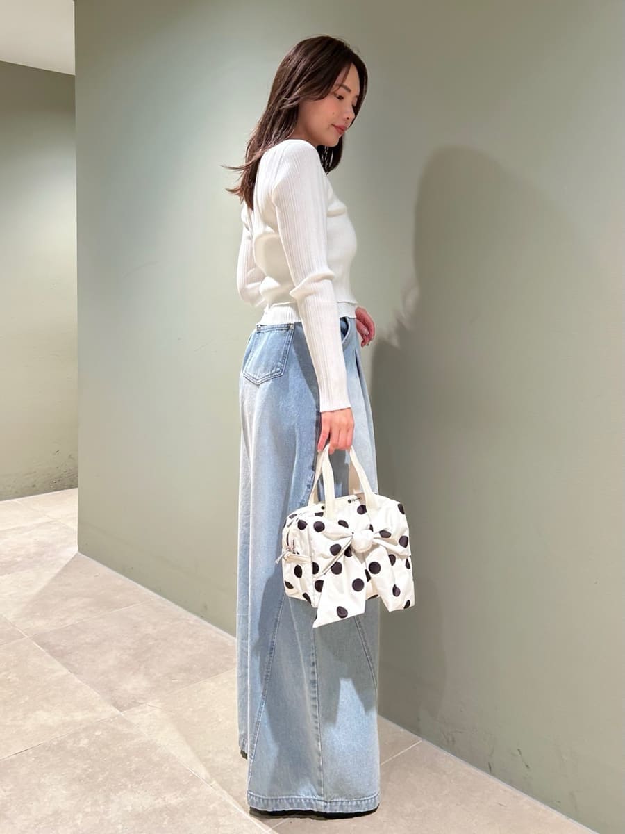 ホワイト系のニット/セーター、ホワイト系のショルダーバッグ、ブルー系のデニムパンツを着用したレディースの夏コーディネートの3枚目の写真
