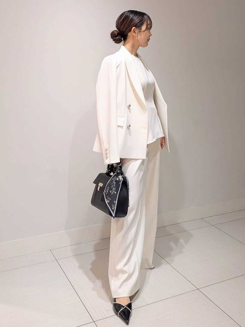 ホワイト系のテーラードジャケット、ホワイト系のワンピース、ブラック系のパンプスを着用したレディースの春コーディネートの2枚目の写真