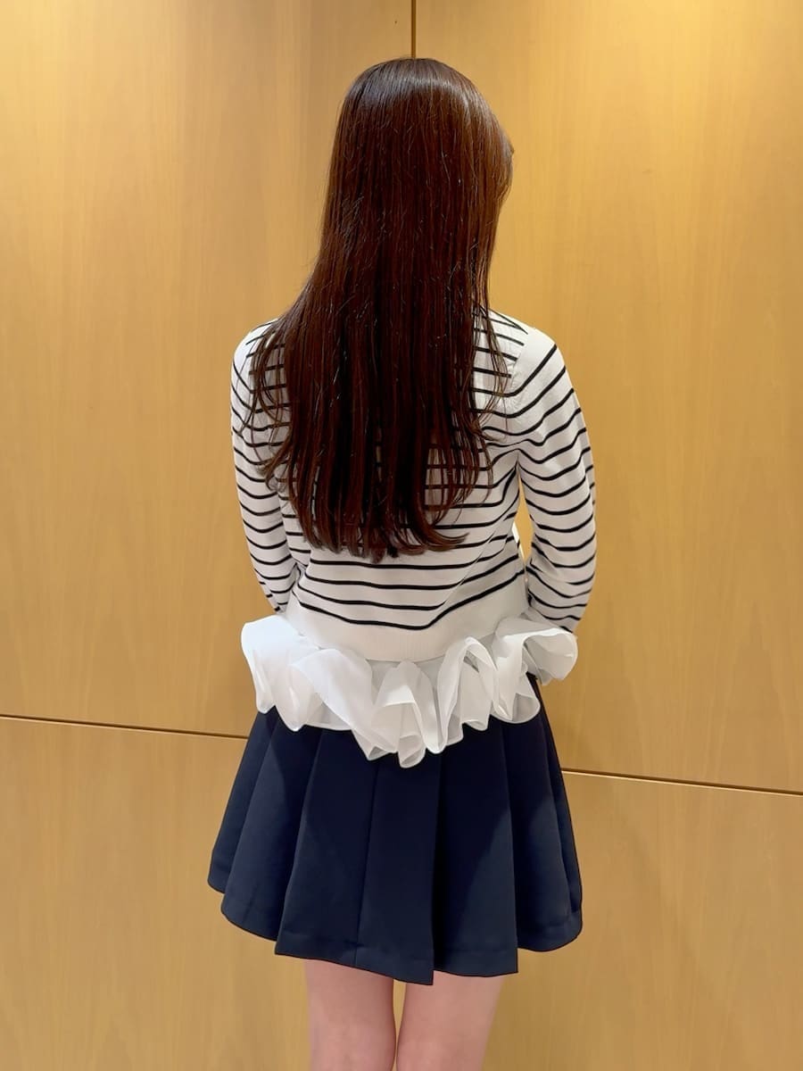 ブラック系のブーツ、ブルー系のスカート、その他のニット/セーターを着用したレディースの冬コーディネートの5枚目の写真