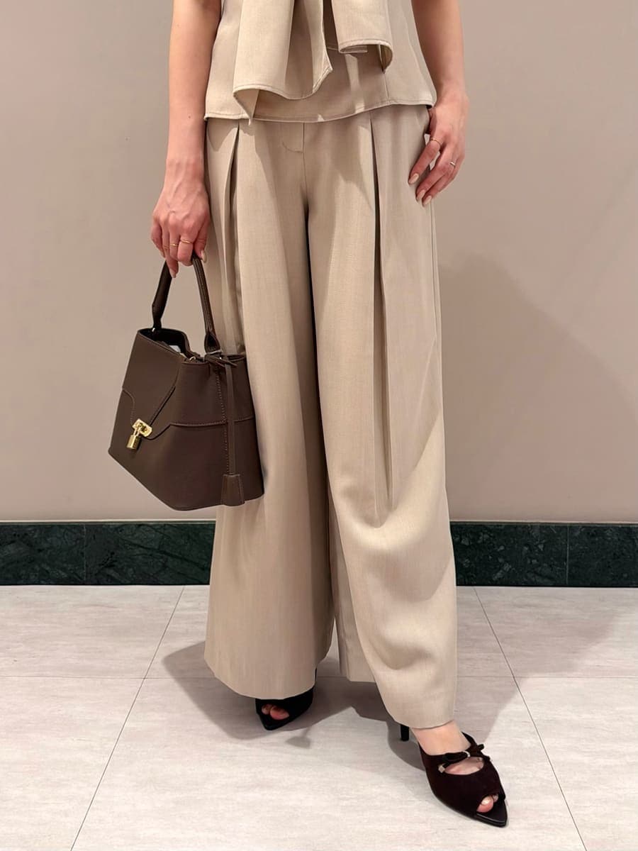 ブラウン系のハンドバッグ、ベージュ系のその他パンツ、ベージュ系のシャツ/ブラウスを着用したレディースの夏コーディネートの6枚目の写真