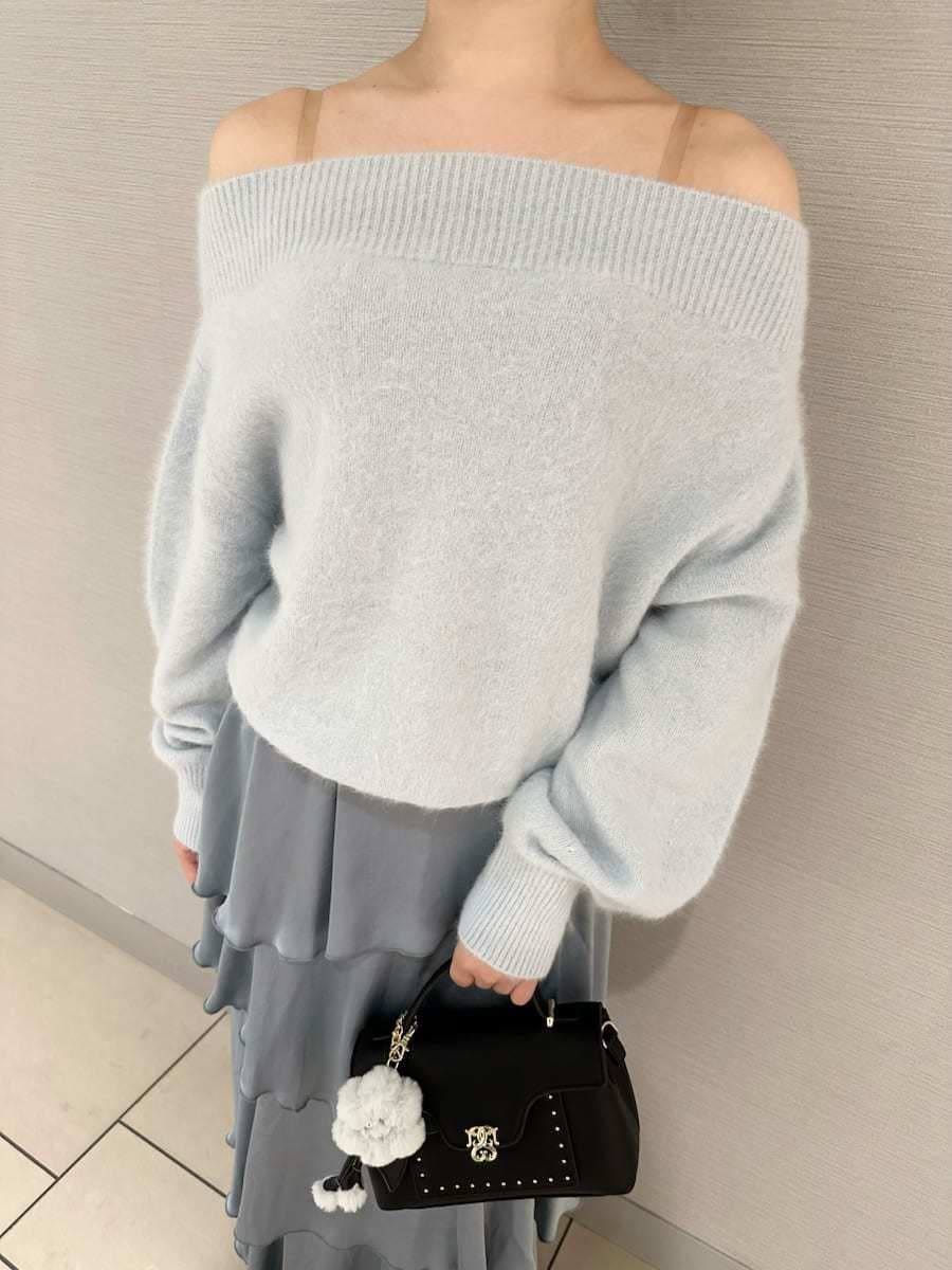 ブルー系のニット/セーター、ブルー系のスカート、ブラック系のブーツを着用したレディースの秋コーディネートの5枚目の写真