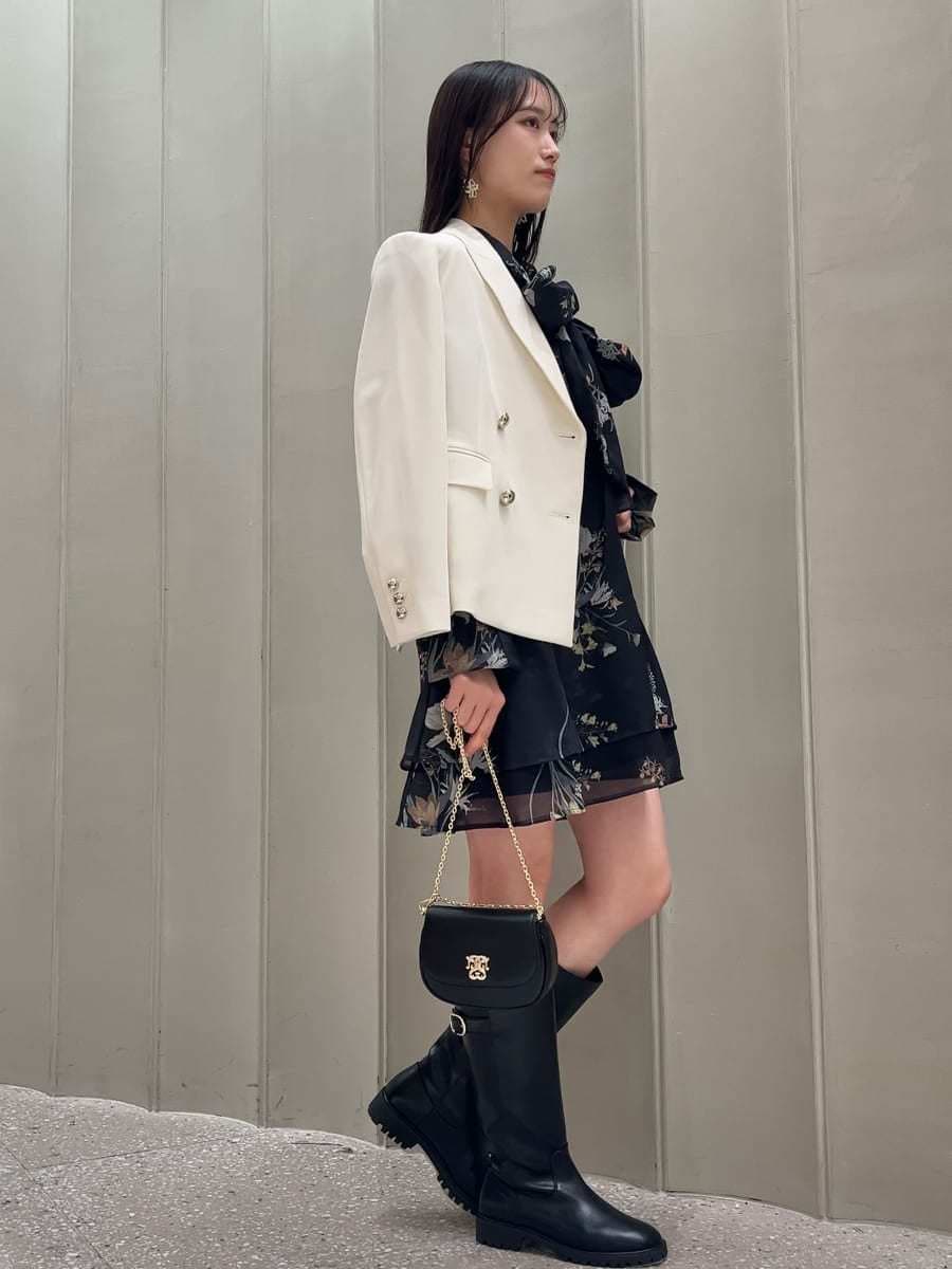 ホワイト系のテーラードジャケット、ブルー系のワンピース、ブラック系のショルダーバッグを着用したレディースの冬コーディネートの3枚目の写真