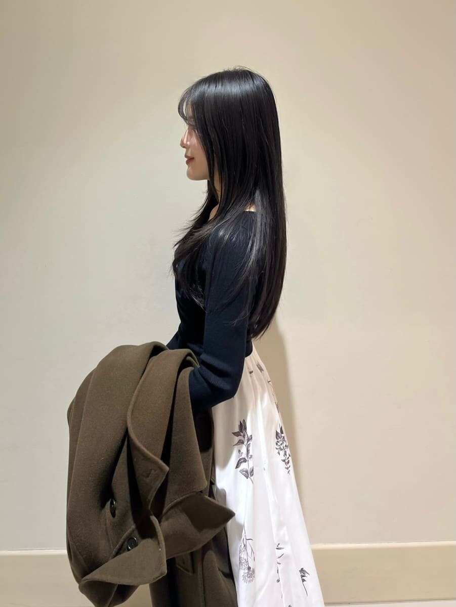 ブラック系のブーツ、ブラウン系のハンドバッグ、ブラウン系のチェスターコートを着用したレディースの冬コーディネートの4枚目の写真