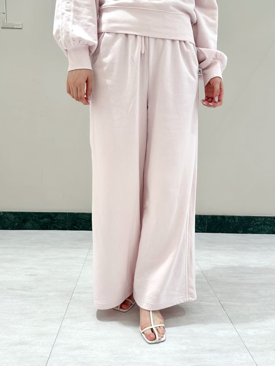 ピンク系のスウェット、ピンク系のスウェットパンツ、ホワイト系のサンダルを着用したレディースの夏コーディネートの3枚目の写真