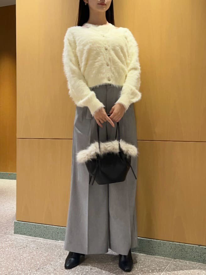 ブラック系のブーツ、イエロー系のニット/セーター、ブラック系のハンドバッグを着用したレディースの秋コーディネートの2枚目の写真